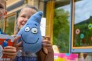 Mädchen hält Maskottchen Flitzi in die Kamera
