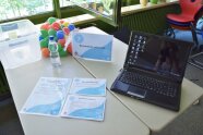 Laptop, Plastikbälle und Wasserflasche auf einem Tisch