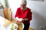 Seniorin formt Knödel aus einem Knödelteig