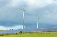 Windkraftwerk und Solarpaneele auf einem Feld