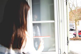 Junge Frau putzt Fenster