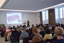 eine Person hält eine Ansprache vor einem Publikum