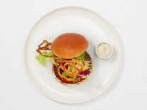aufgeklappter Hamburger auf weißem Teller