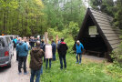 Menschen stehen neben einer Hütte im Wald