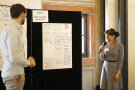 Eine Frau und ein Mann präsentieren Ergebnisse anhand von aufgehängten Flipcharts