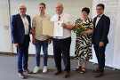 Fünf Personen, einer hält eine Urkunde
