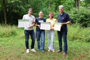 Vier Personen mit Schildern