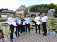 Sechs Personen stehen auf einer Terrasse 