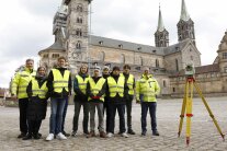 12 Personen in gelben Warnwesten vor dem Bamberger Dom