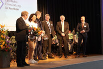 Die drei fränkischen Amtsleiter auf der Bühne bei der Geschenkübergabe an Dr. Markus Söder und Michaela Kaniber