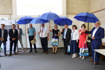 Eine Gruppe von Personen in einem Raum mit aufgespannten Regenschirmen