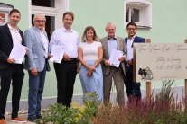 Sechs Personen stehen vor einem Gebäude