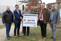 Fünf Männer stehen um ein Förderschild