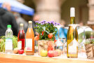 Verschiedene Säfte und eind Flasche Wein mit Blumen schön drapiert.